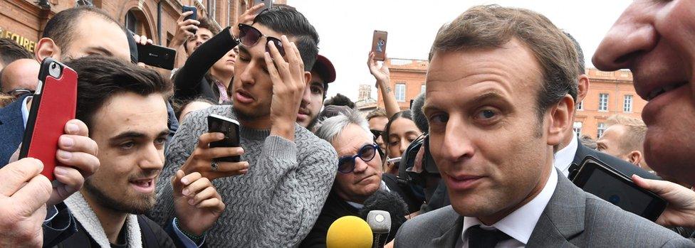 French President Emmanuel Macron speaks with people at the Place du Capitole in Toulouse, southern France