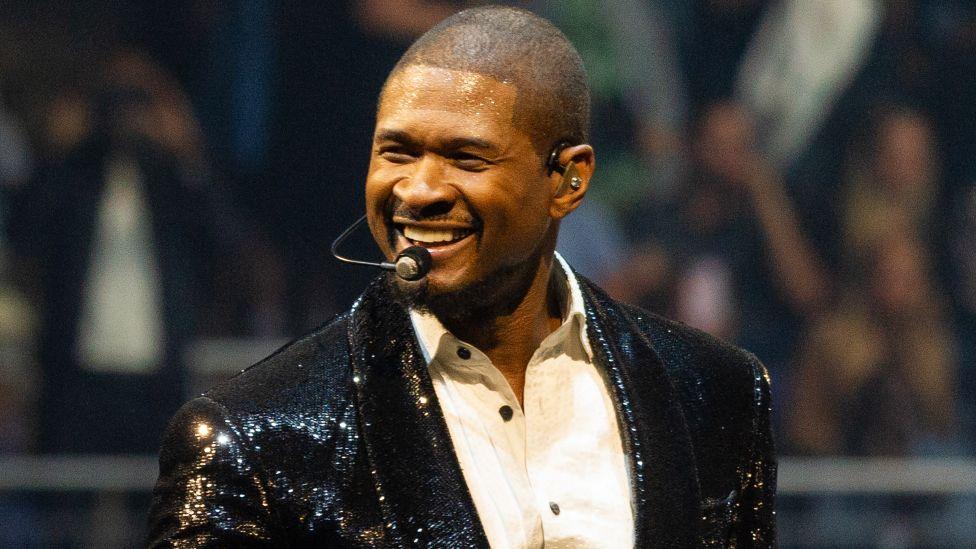 Usher performs in a black, sequinned jacket and white shirt on stage on night 8 of his Past Present Future tour at The O2 Arena on April 11, 2025 in London, England