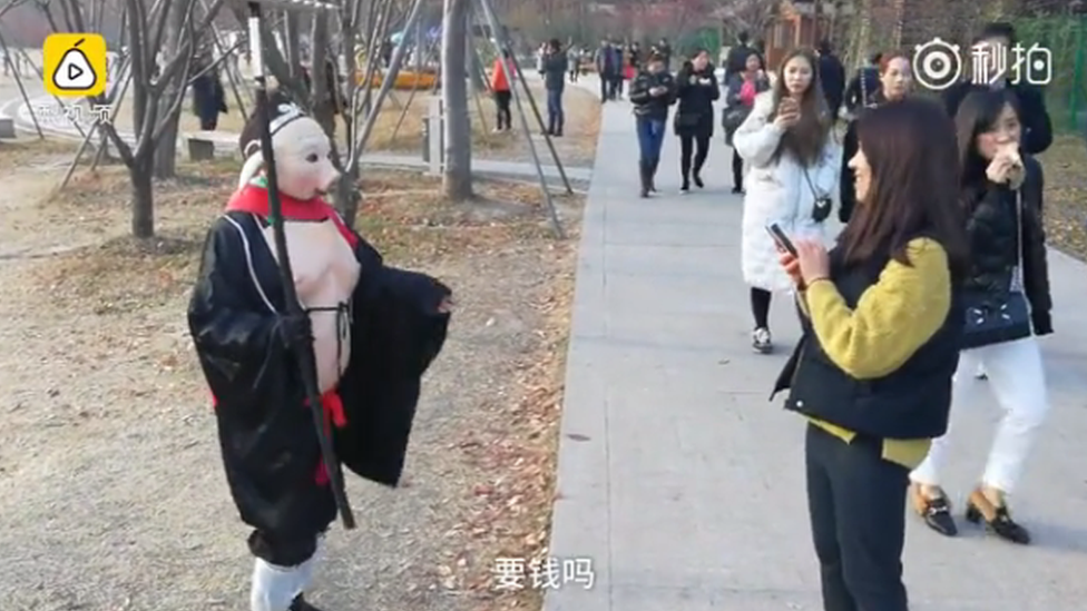 A passerby asks "do you want money?" after Wu Xiue posed for a picture dressed as 'Pigsy' from novel Journey to the West