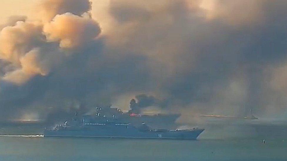 Smoke billowed from the port of Berdyansk as two ships raced away