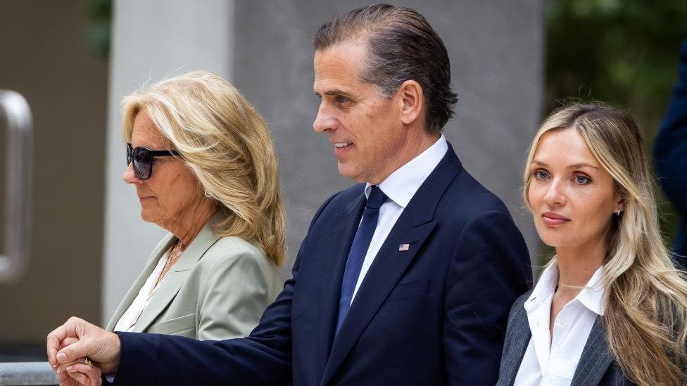 Hunter Biden (C) holds hands with First Lady Jill Biden (L) and wife Melissa Cohen Biden (R)