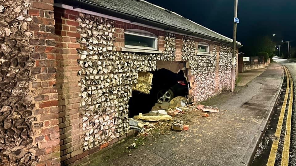 Building wall with a hole after car smashes into it