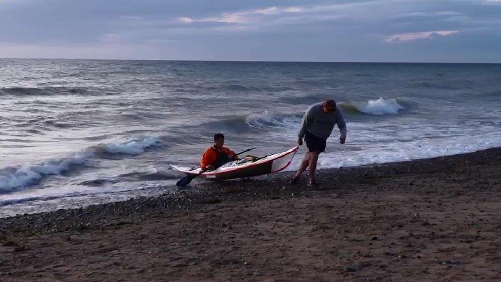 Kim Tastagh's kayak being pulled onto the beach