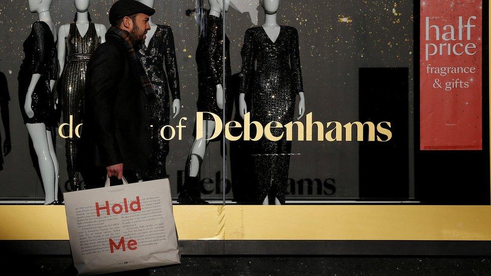 Man walking in front of Debenhams window