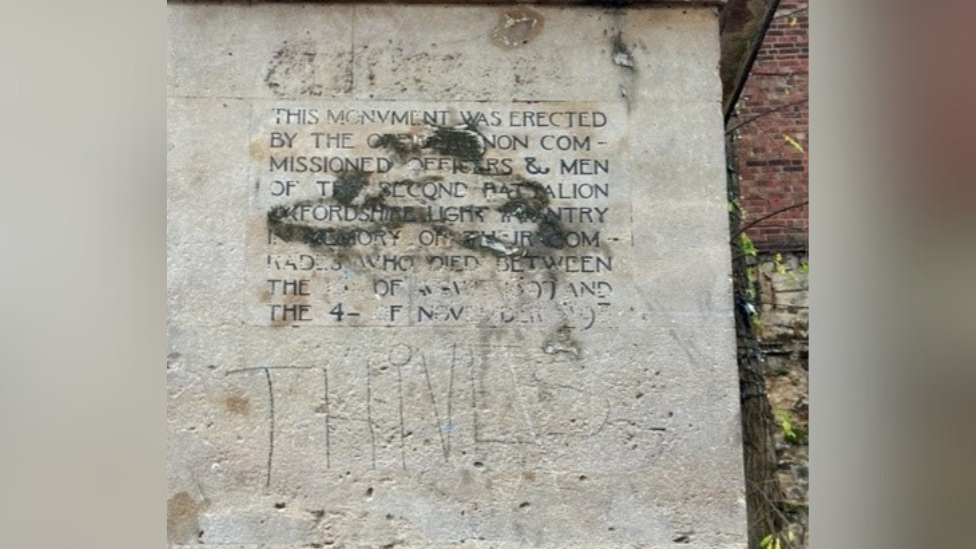 A close-up of the Tirah Memorial in Oxford. Black paint is covering writing explaining what the white stone memorial is remembering. The word 'Thives' [sic] is written in pen below the black paint.