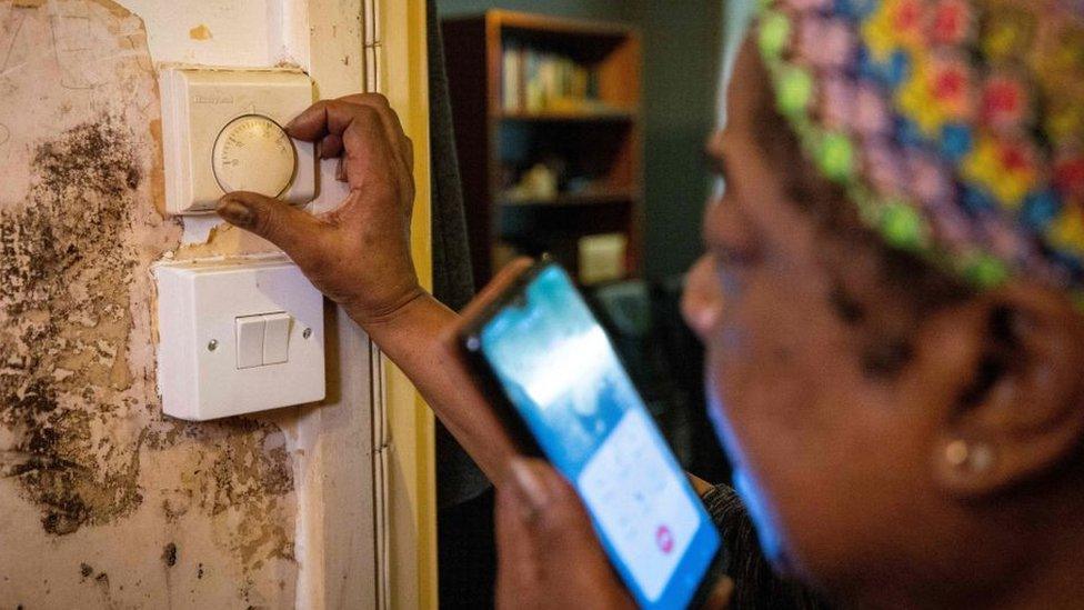 A woman turning up the heating