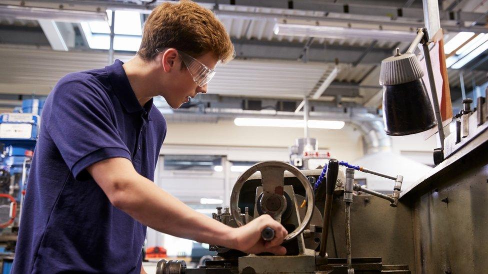 Apprentice using a lathe