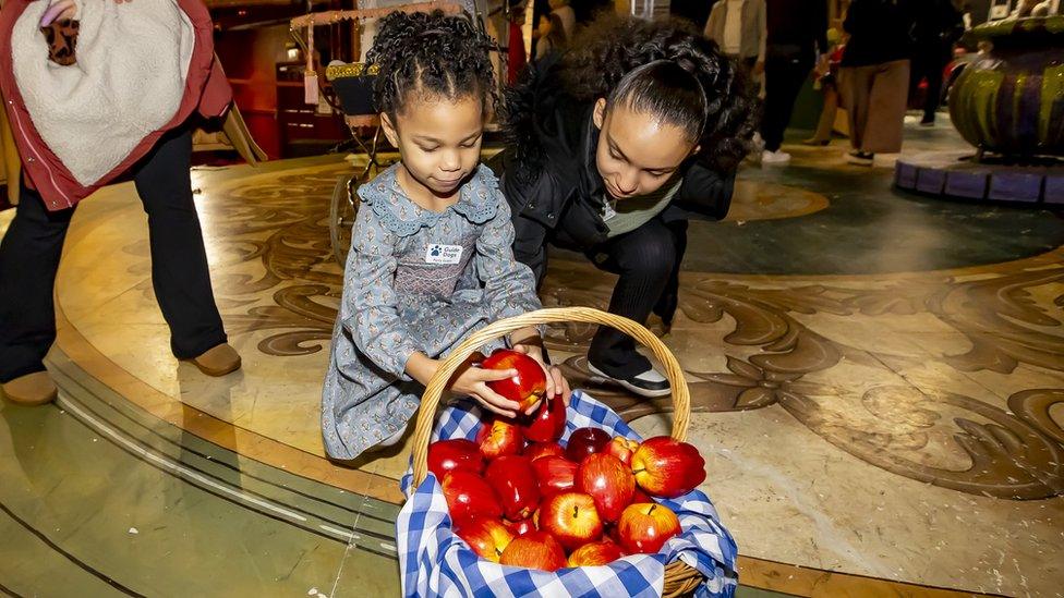 Two girls with theatre prop of Snow White's apples