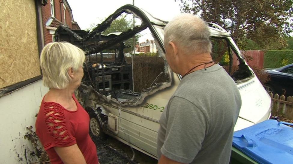 Julie Broomfield and Steve Boyd look at their burnt out caravan