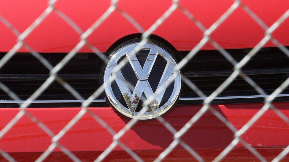 A Volkswagen diesel sits behind a security fence