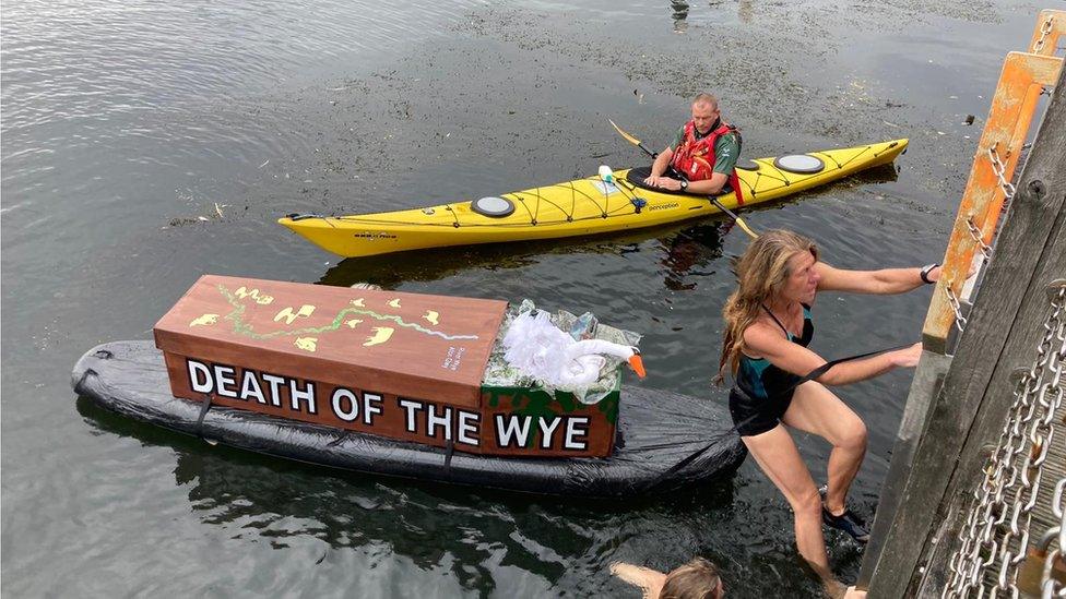 Angela Jones on a ladder and a man in a canoe on a river