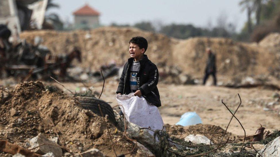 A Palestinian boy cries as he stands amid debris in the Maghazi in central Gaza