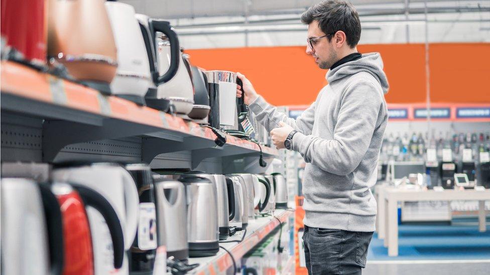 Customer choosing a kettle in a shop