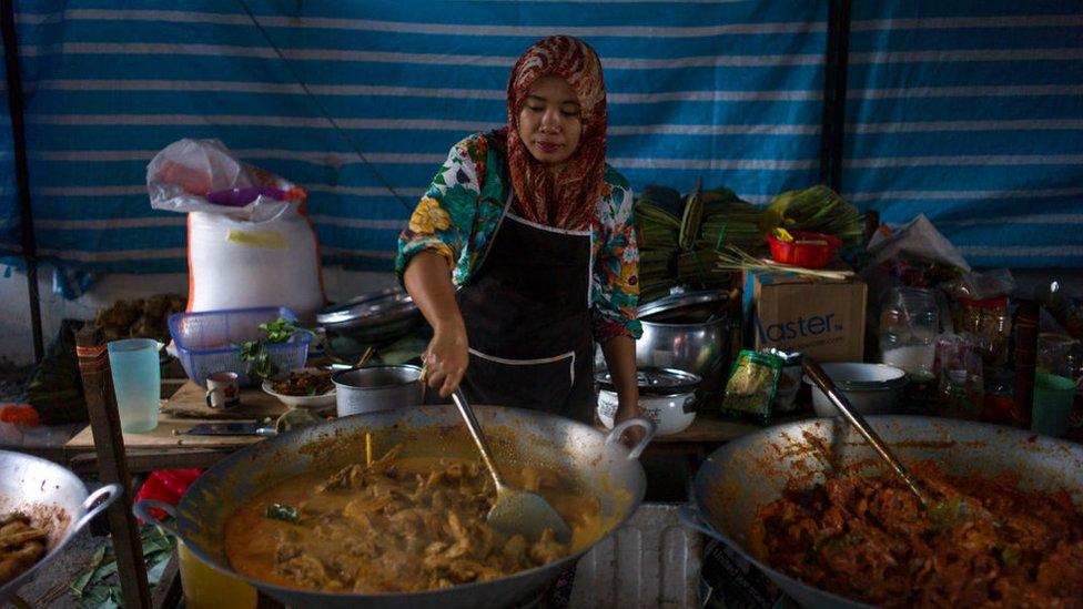 Menyw yn coginio Ayam Rendang yn Malaysia