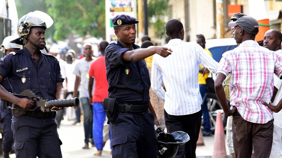 Police gesture to people near Independence Square in Dakar on July 25, 2017