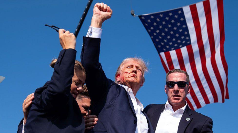 Donald Trump pumps his fist in the air, moments after an assassination attempt on him on 13 July 2024