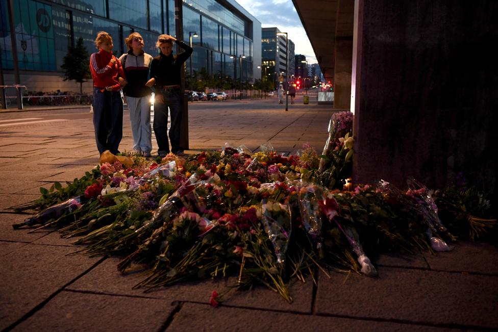 People lay flowers laid near the Field's shopping centre, a day after a shooting at the site in Copenhagen, Denmark, 4 July 2022.