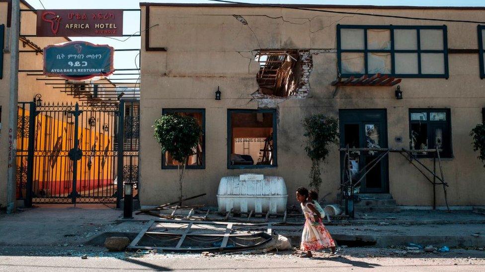 Children play in front of a hotel damaged by mortar shelling, in Humera, Ethiopia, on November 22, 2020.