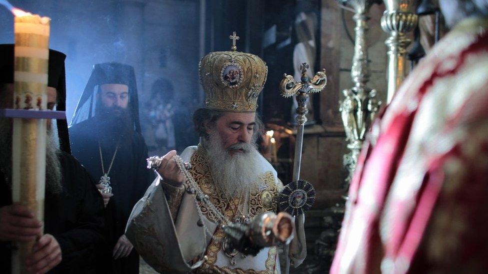 Greek Orthodox Patriarch of Jerusalem Metropolitan Theophilos (C) walks during Easter service in the Church of the Holy Sepulchre in Jerusalem's Old City