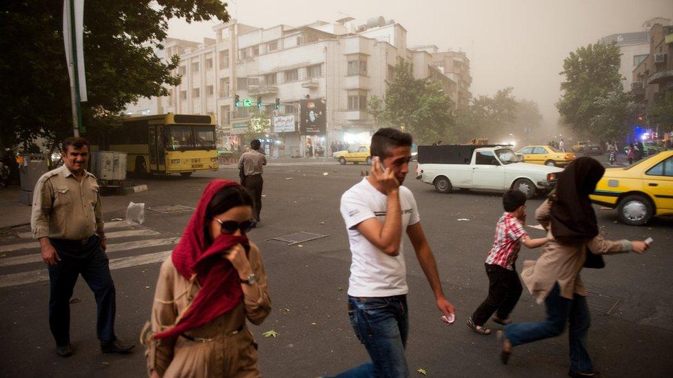 Iranians walk amid a sand storm in Tehran (2 June 2014)