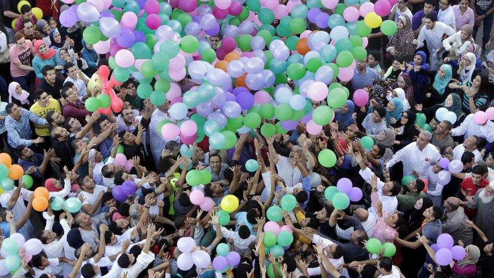 Egyptians catch balloons at Eid