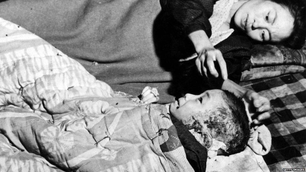 A mother tends her injured child, a victim of the atomic bomb blast at Hiroshima