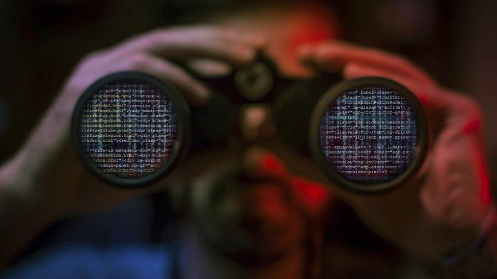 A man looks at data through binoculars