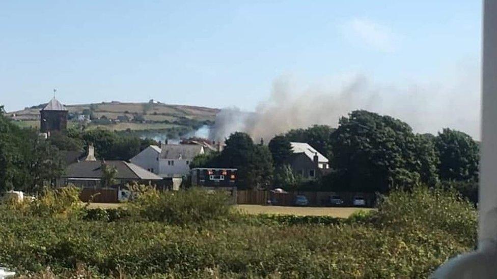 Smoke rising near houses