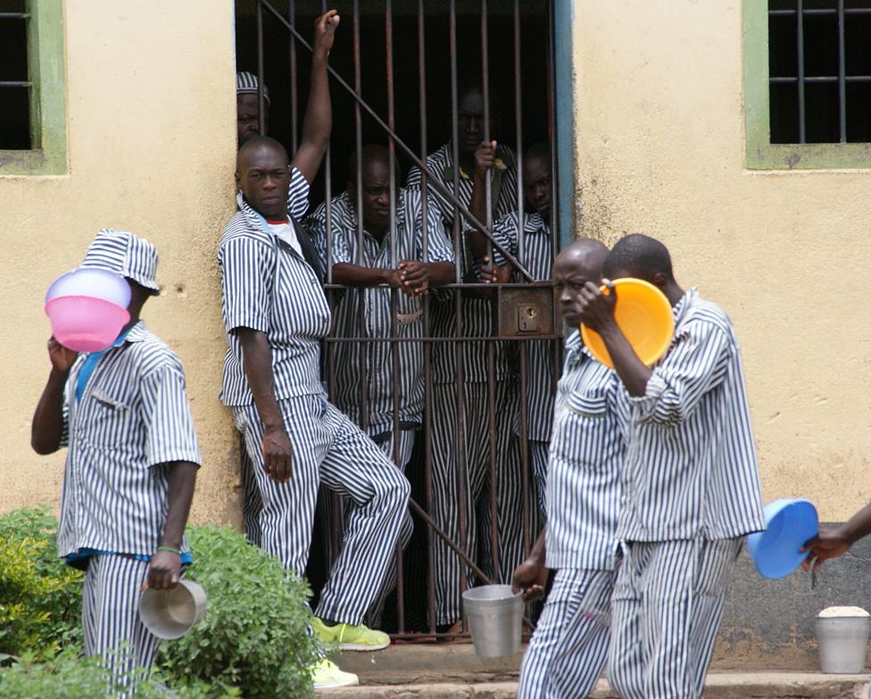 Prisoners hang around a cell