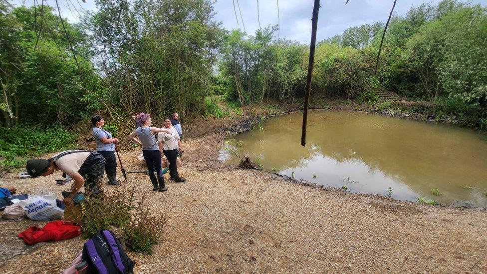 People next to a pond