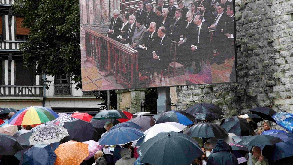 Mourners watch the funeral service outside the cathedral