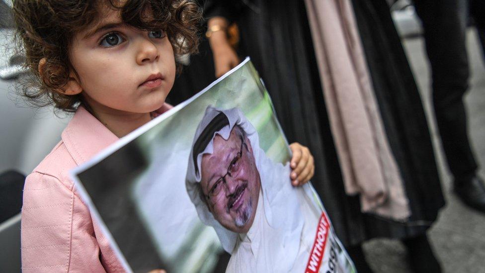 A child holds a sign for missing journalist