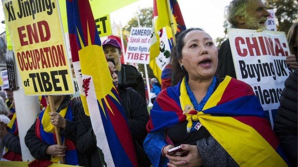 Pro-Tibet protesters hold placards and chant slogans as they demonstrate on Parliament Square,