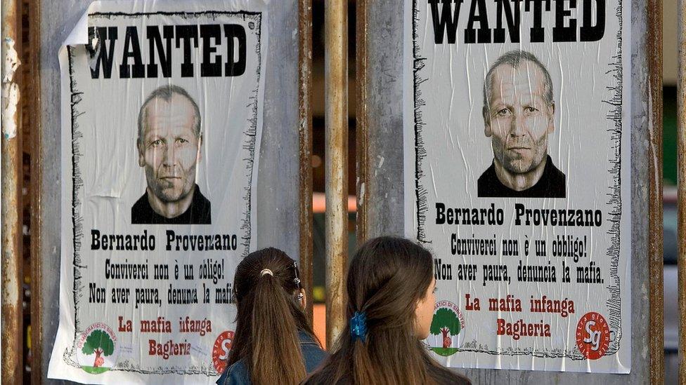 Girls view posters of the Sicilian Mafia's top chief Bernardo Provenzano in Bagheria on the outskirts of Palermo, Sicily, 28 April 2005