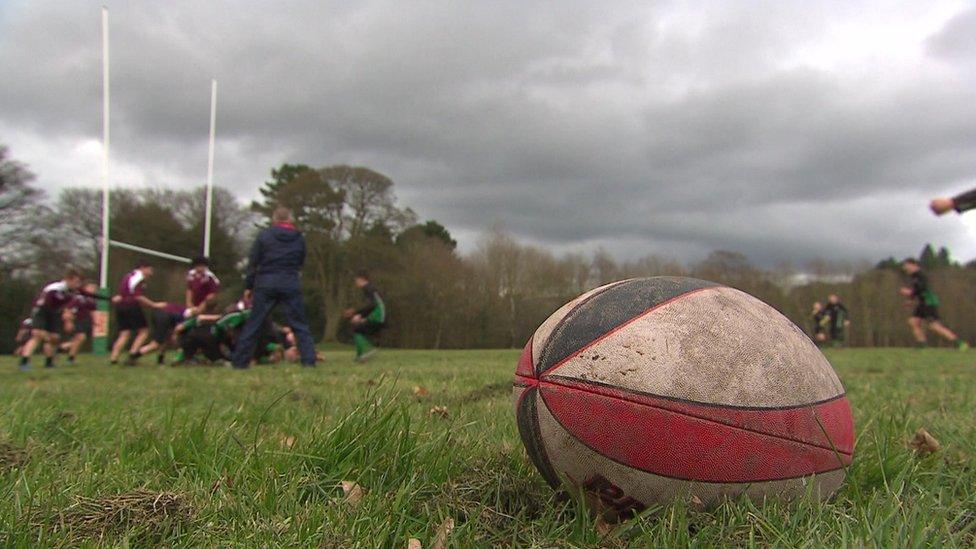 Rugby ball with kids playing in the background