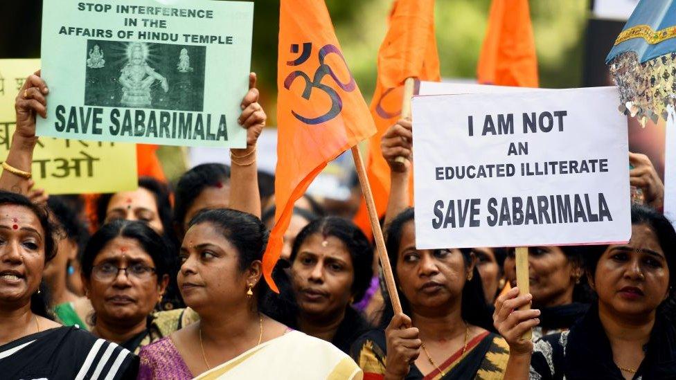 Women protesting with billboards saying, "Save Sabarimala"