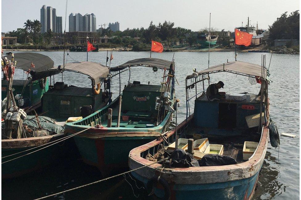 Fishing boats flying red flags in a harbour in Baimajing, Hainan province, 7 April 2016.