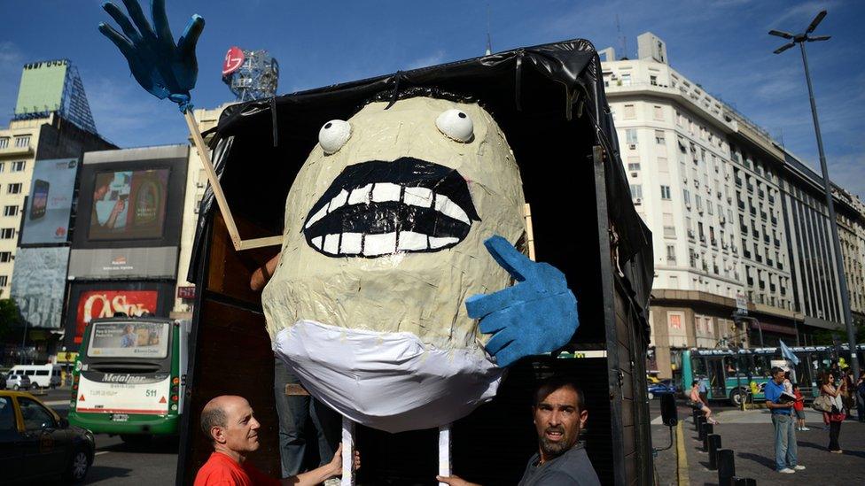 Men carry a giant gnocchi dummy during a demo against the massive firing of civil servants in downtown Buenos Aires, on 29 January 2016