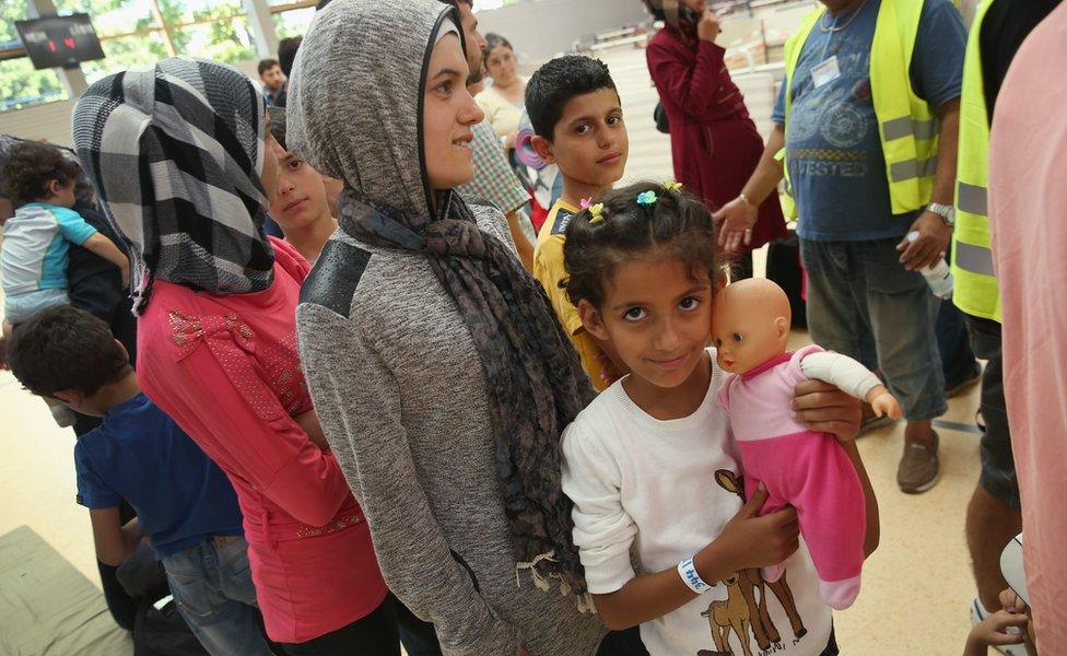 Some young women, mostly from Syria, prepare for registration at a facility of the German Federal Police in Deggendorf, Germany