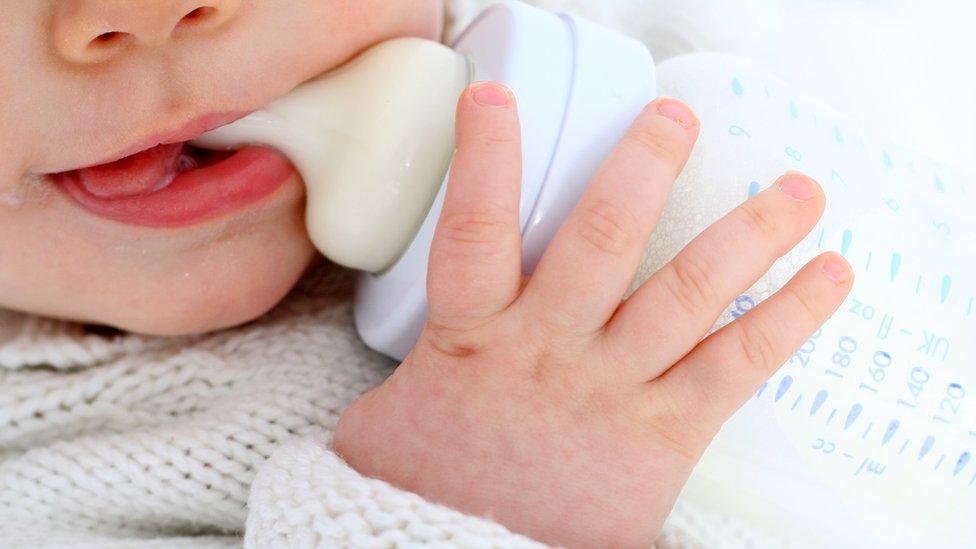 An unidentified baby with a bottle