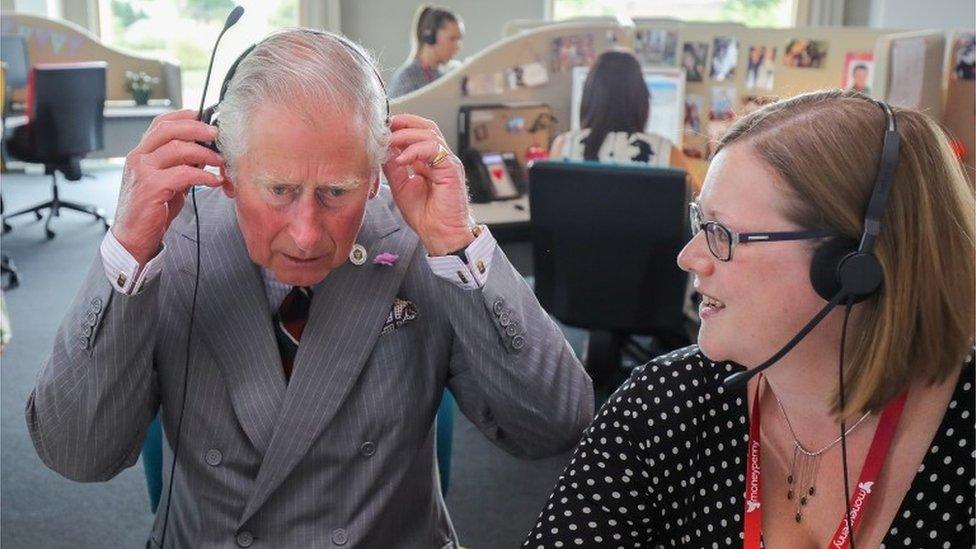 Prince Charles listens in to a telephone call during a visit to Moneypenny Ltd