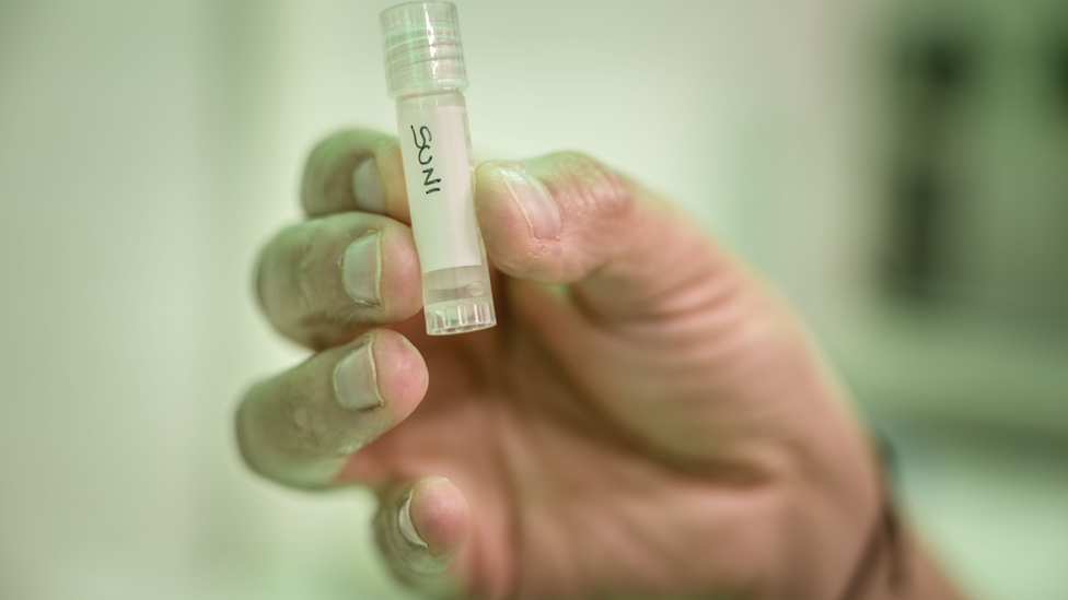 Cesare Galli holding a capsule labelled Suni