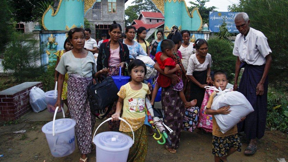 Rakhine ethnics who fled from fighting area carry their belongings as they arrive to take refuge at a monastery in Boothee Taung town, Rakhine State, western Myanmar, 13 October 2016.