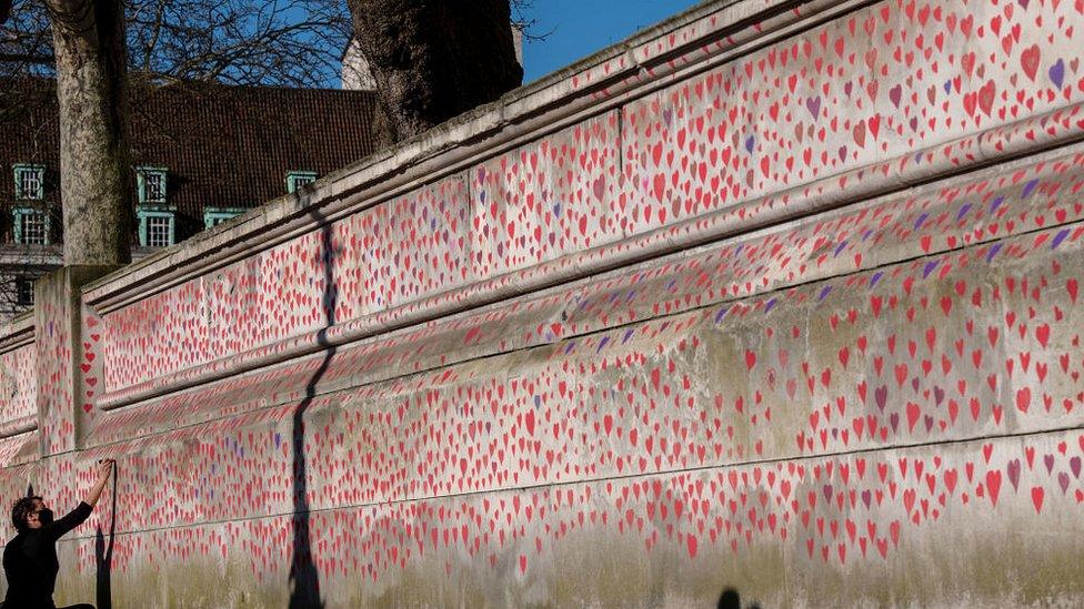 A wall of painted pink and purple hearts