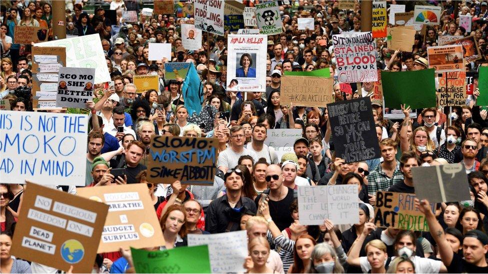 Demonstrators hold up placards at a climate protest rally in Sydney on 11 December, 2019