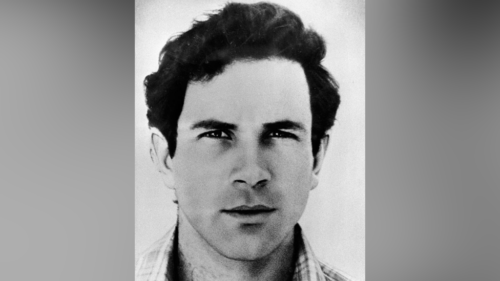 A black and white portrait photograph of Yonatan Netanyahu. Blurred grey bars are either side of the photo. 