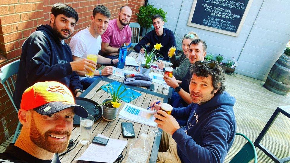 Keith Moule, Tom Sharpe and their support crew sitting at a table