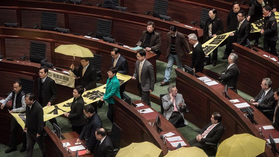 Pro-democracy lawmakers walk out in protest before the policy address of Hong Kong Chief Executive Leung Chun-ying in the legislative council in Hong Kong on January 14, 2015