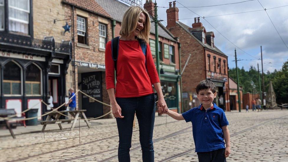 Woman holds boy's hand in Beamish main street