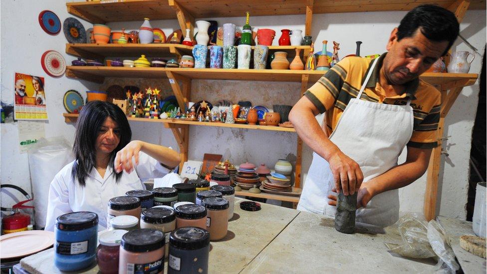 An Afghan refugee works on a pot in the pottery workshop of the Citta' Futura Project on June 22, 2011 in Riace.